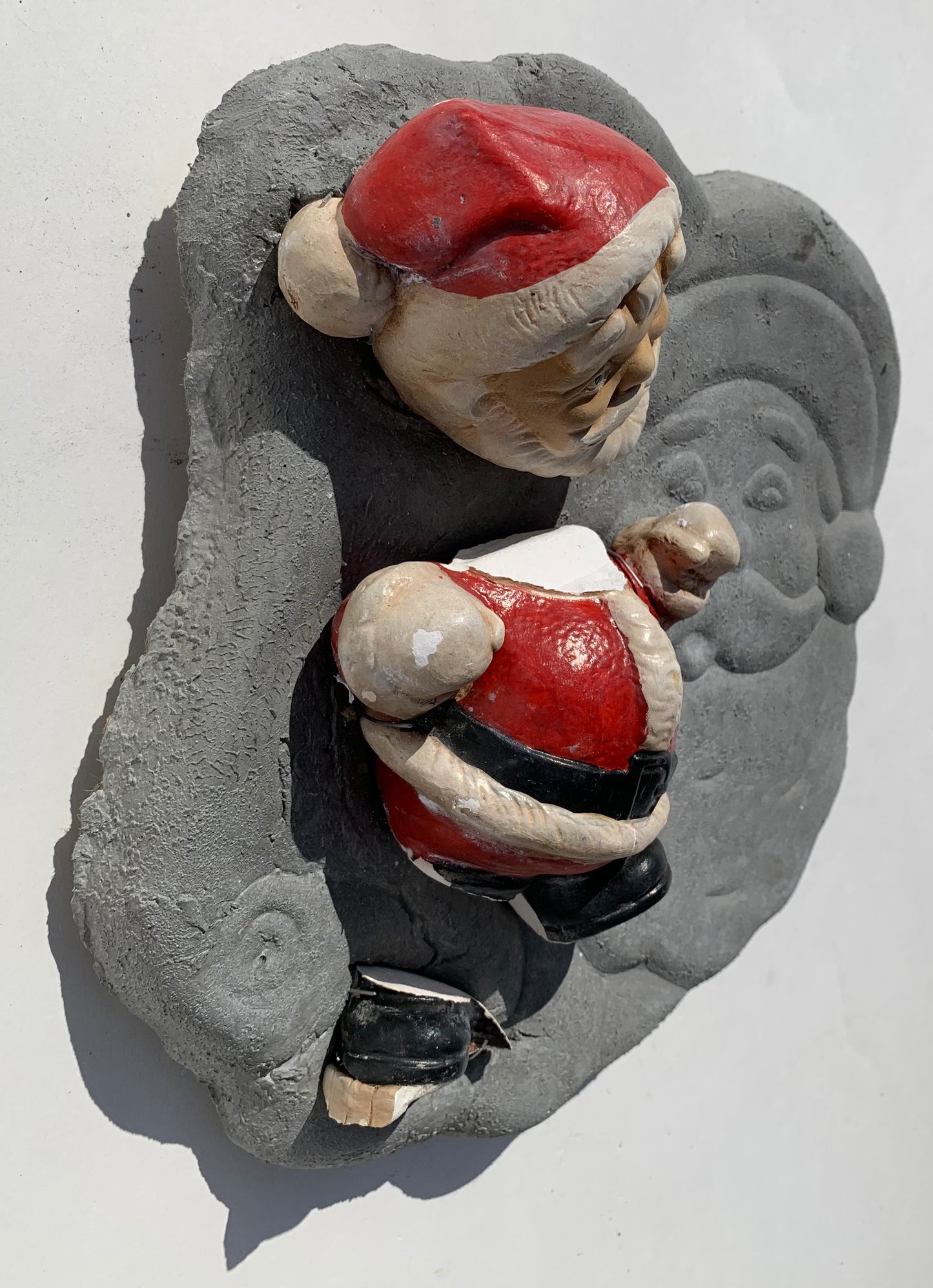 "Seasonal Discombobulation": Club-fisted Santa on Listing Santa Wall Sculpture